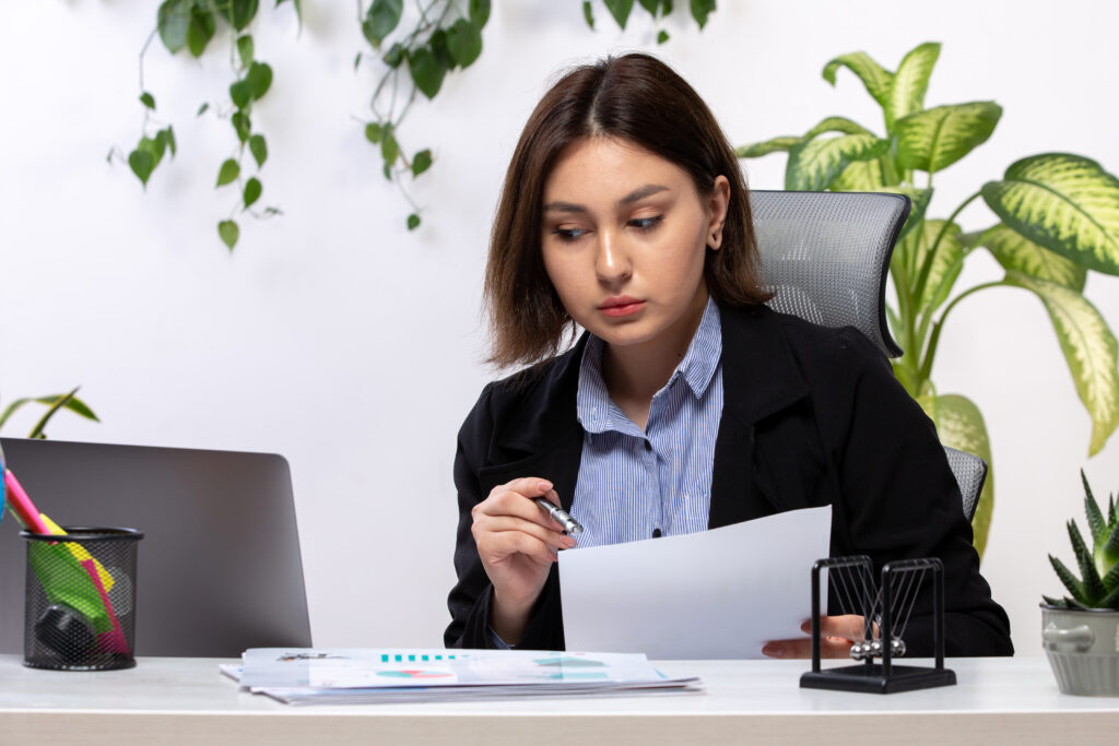 front view beautiful young businesswoman black jacket blue shirt working with laptop documents front table business job office